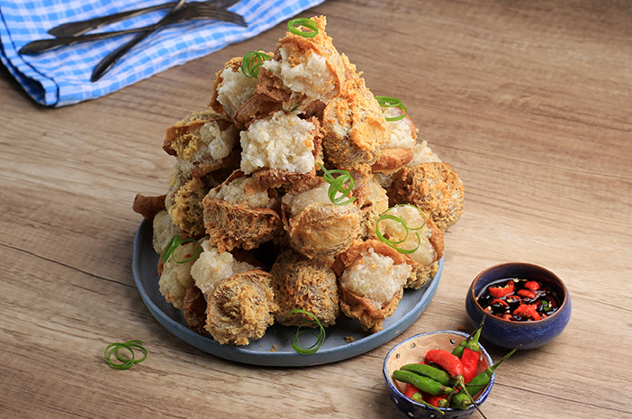 Sepiring tahu goreng ayam yang renyah di luar dan lembut di dalam, disajikan dengan saus sambal yang pedas dan gurih